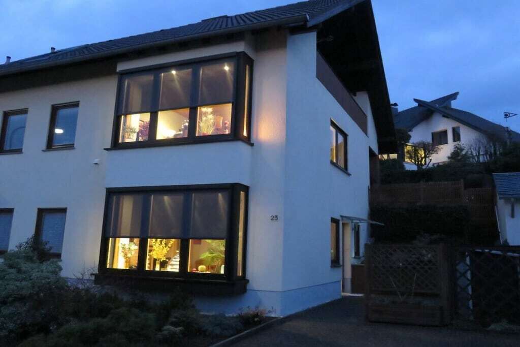 A modern two-story house with large windows and a visible number '23' on the facade.