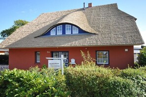 A red building with a peaked roof and a sign reading 'Buttenhaus.' - Morning sun in Bültenhus (Born\/Darß)