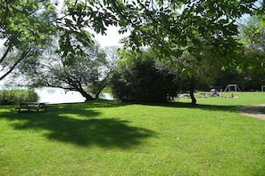 A grassy park area with a picnic table and playground equipment. - at Lake Selent in Pülsen (Pülsen)