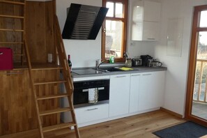 Eine kompakte Küche mit Backofen, Geschirrspüler und einem Fenster mit Blick.