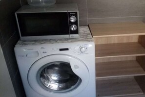 A compact washer and dryer unit with a control panel and a microwave on top. - Villa Belair Schmidt (Wurster Nordseeküste Ortsteil Dorum-Neufeld)