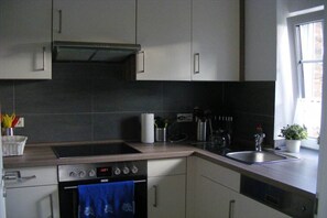 A modern kitchen with a built-in oven, a stovetop, and a sink. - Villa Belair Schmidt (Wurster Nordseeküste Ortsteil Dorum-Neufeld)