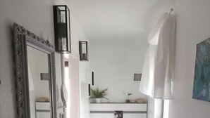 Un bagno piccolo ma funzionale, con lavandino, WC e specchio.