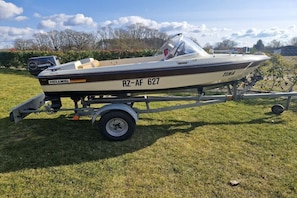 Ein Boot mit Anhänger auf einer Wiese.