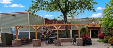 A building with a covered patio area, outdoor seating, and a sign that reads 'Malligans.'