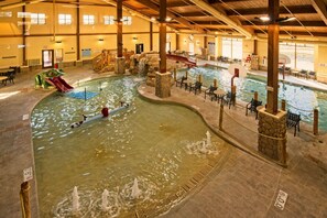 Une piscine intérieure dotée de plusieurs couloirs de nage, d’espaces pour se détendre et d’un toboggan.