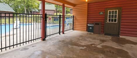 A covered outdoor area with a pool, a fenced-in section, and a door labeled 'Loo Cabin Laundry.'