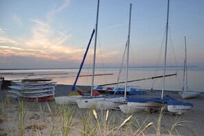 A beach with several sailboats docked on the sand, a calm sea in the background, and a clear sky. - Holiday home in Glowe with swimming pool (Glowe)