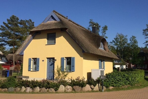 A yellow house with a thatched roof, blue shutters, and a small window. - Holiday home in Glowe with swimming pool (Glowe)