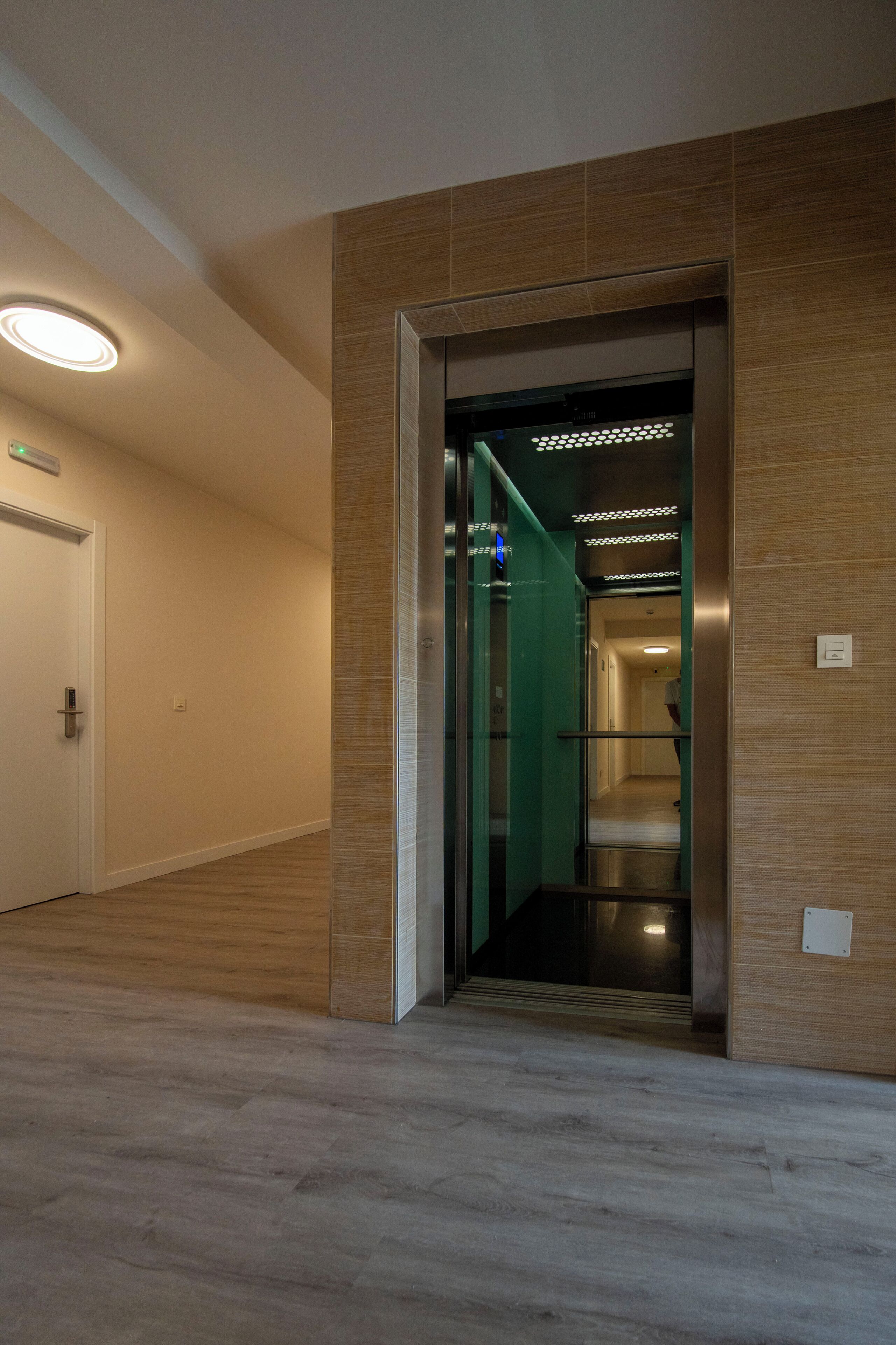 A modern elevator with a glass door and a digital display.