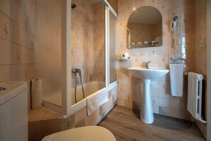 Een badkamer met een bad, een wastafel en een toilet.