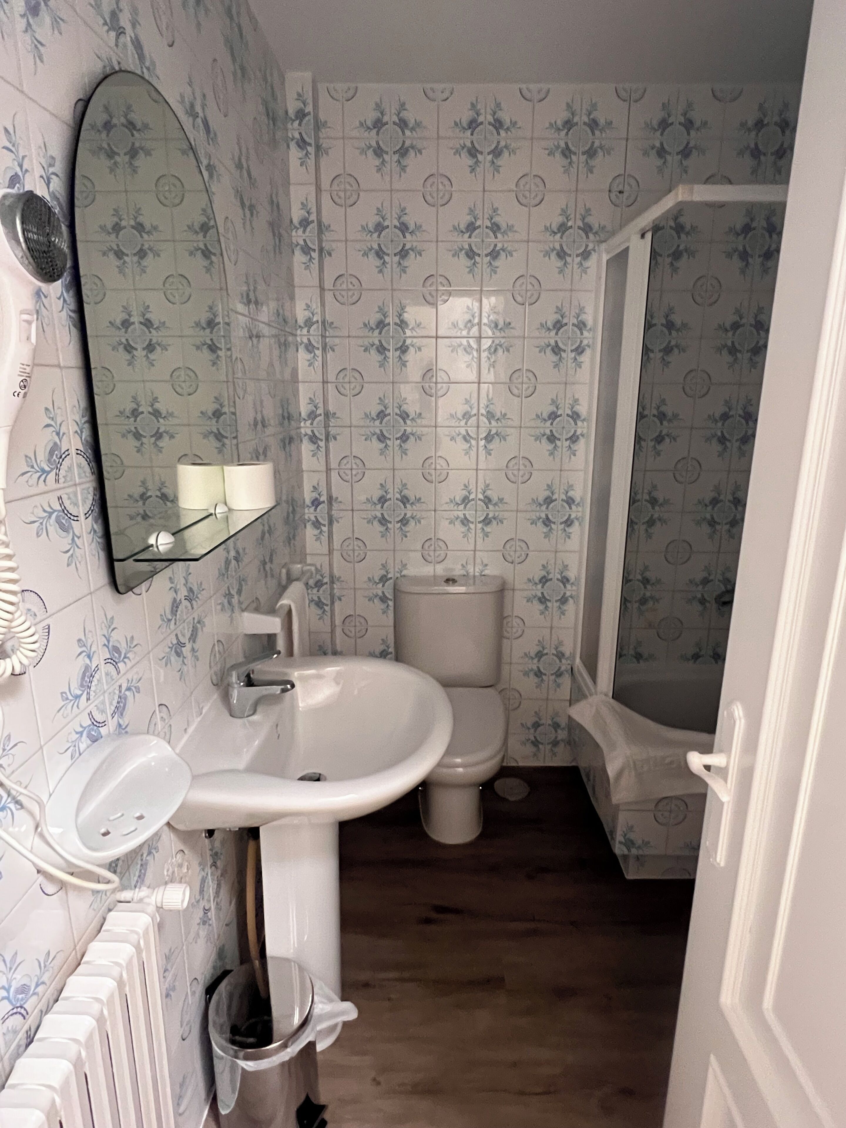 Une salle de bain avec un lavabo blanc, des toilettes et un espace douche.