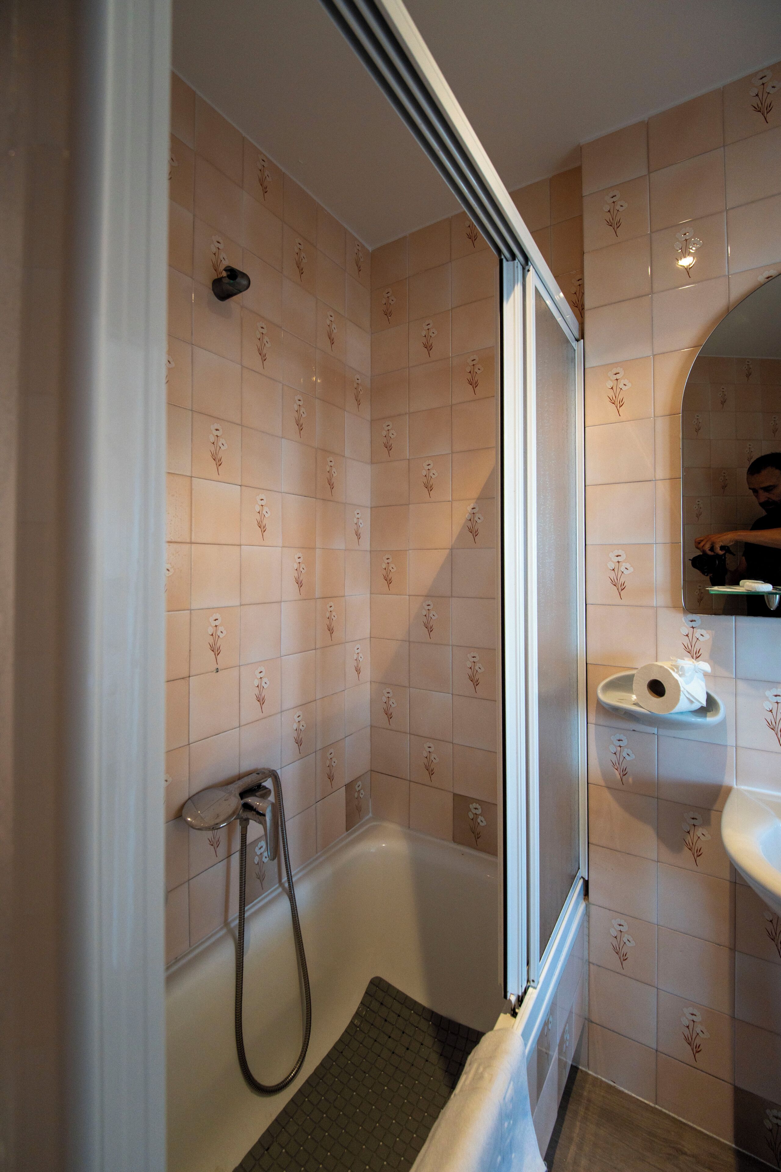 Een badkamer met een douche, toilet en wastafel.