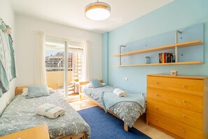 Ein Schlafzimmer mit zwei Betten, einem Holzkapuzen-Kommode und einem Bücherregal.