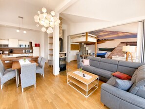 A modern living space with a sofa, coffee table, and dining area. - Vacation Rental with Ocean View (Sassnitz)