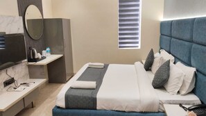 Een hotelkamer met een bed, nachtkastje en een bureau met stoel.