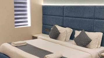 A modern bedroom with a large bed, a ceiling fan, and a window with blinds.