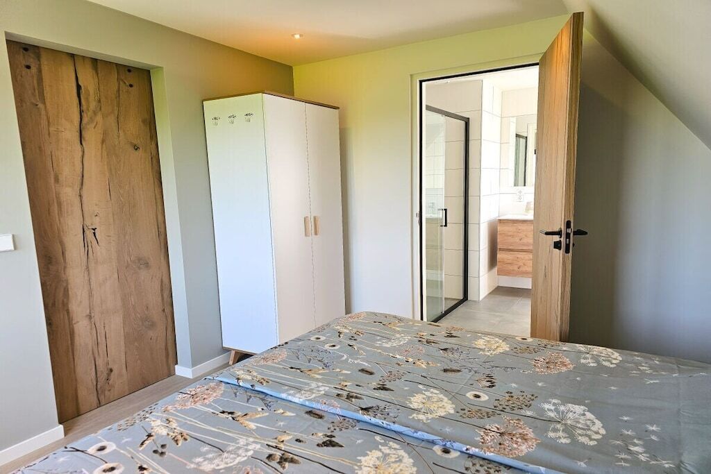Ein Schlafzimmer mit Bett, Schrank und einer Tür zu einem Badezimmer.