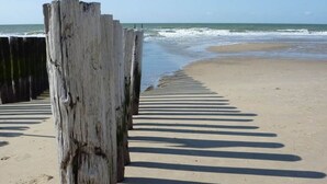 A beach with wooden posts and shadows on the sand. - DO19 Holiday home Domburg (Domburg)