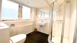 A modern bathroom with a toilet, sink, and shower. - DO19 Holiday home Domburg (Domburg)