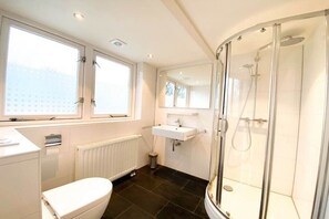 A modern bathroom with a toilet, sink, and shower. - DO19 Holiday home Domburg (Domburg)