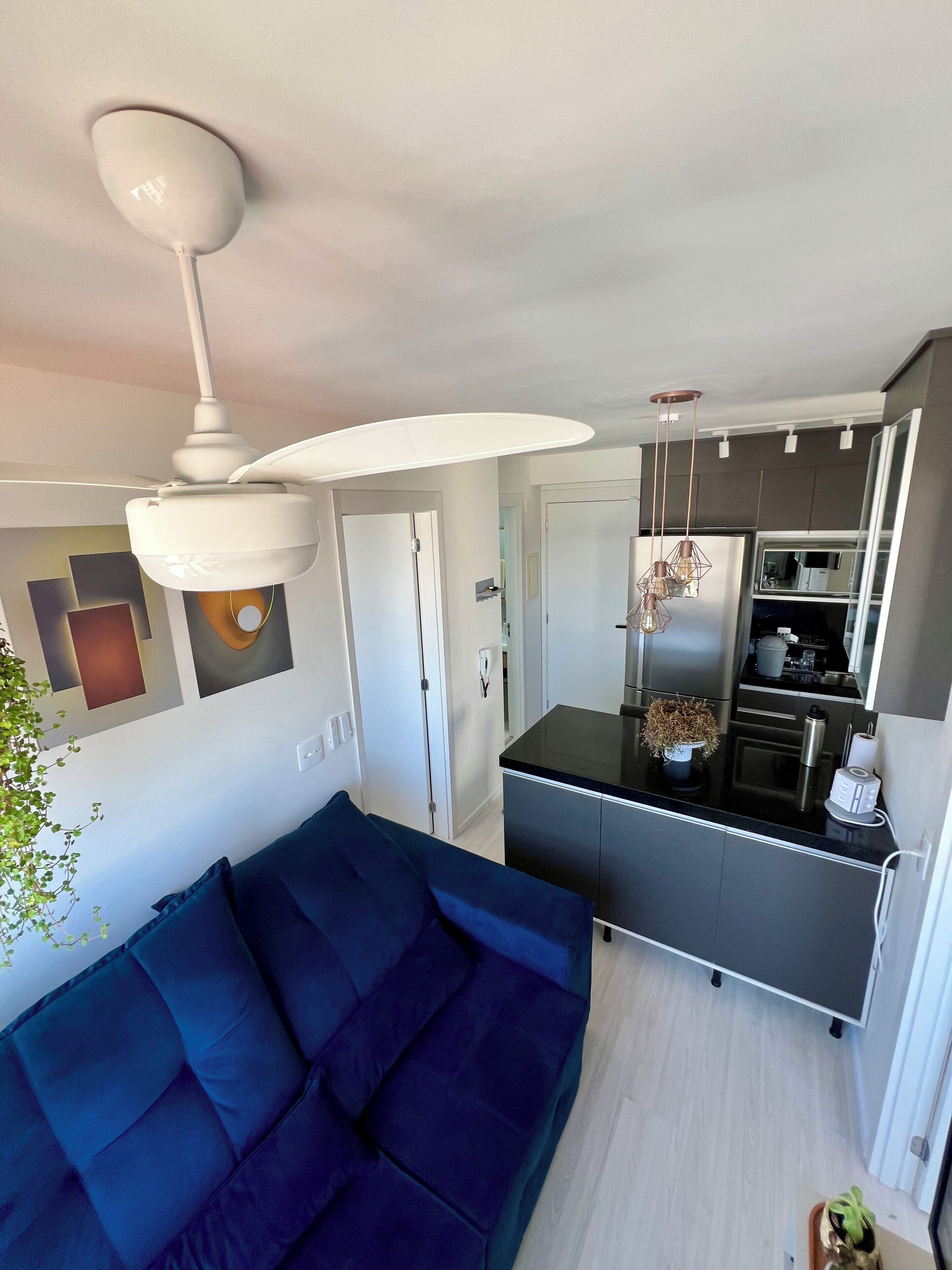 A modern kitchen with a central island, a built-in oven, and a stainless steel refrigerator.