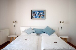 A double bed with white bedding and two bedside tables, one on each side. - at the Johanneshof winery (Minheim)