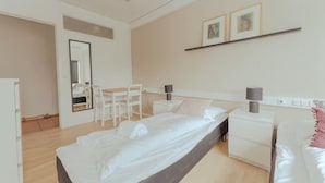 Een hotelkamer met een bed, nachtkastjes, een bureau, een stoel en een spiegel.