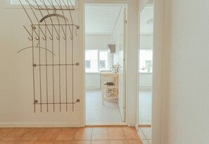 Ein Zimmer mit einer Tür, die in einen Küchenbereich führt.