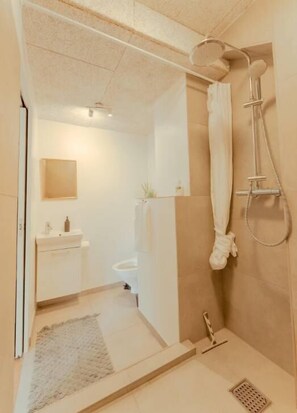 Ein Badezimmer mit Dusche, Toilette und Waschbecken.