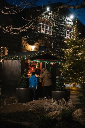 A building with a stone facade, a green awning, and a Christmas tree with lights. - 3BR Spacious Apartment in the heart of City Center (Tórshavn)