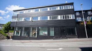 En modern byggnad i två våningar med stora fönster och ett platt tak.