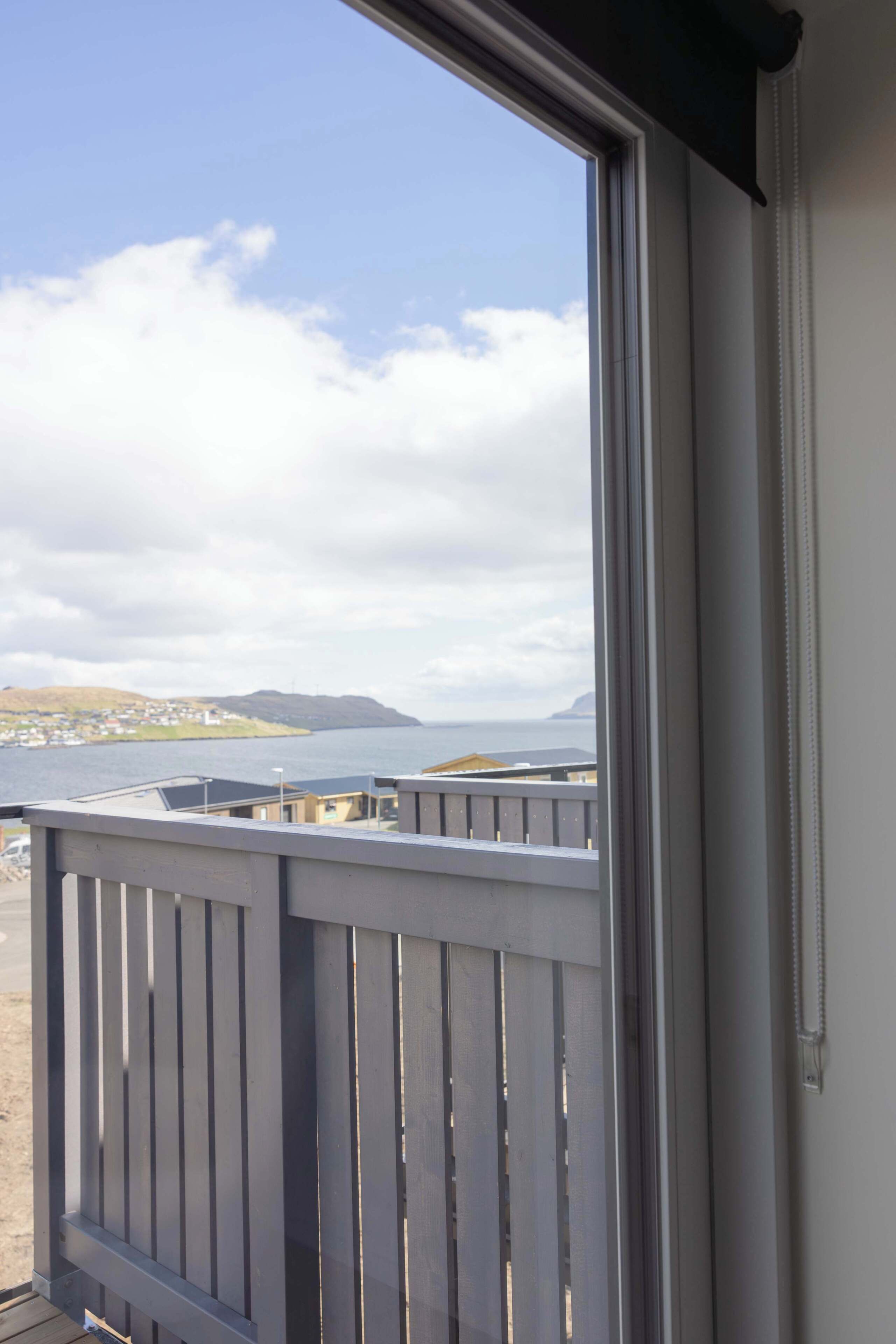 Un balcon donnant sur une étendue d’eau et sur une terre lointaine.