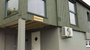 Un edificio con un letrero que dice 'Grasastova' y una puerta con un ventanal en forma de rombo.