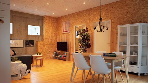 Un salon moderne avec une cheminée, un téléviseur et un coin repas.
