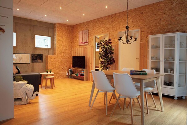 A modern living room with a fireplace, television, and dining area. - Cozy & Characterful Faroese Apartment - 2 Bedrooms (Tórshavn)