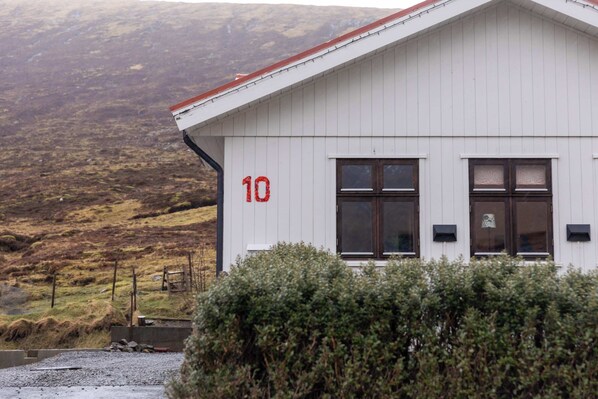 A white building with the number 10 on its side, surrounded by vegetation.
