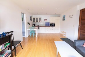 A modern apartment with a dining area, kitchen, and living space.