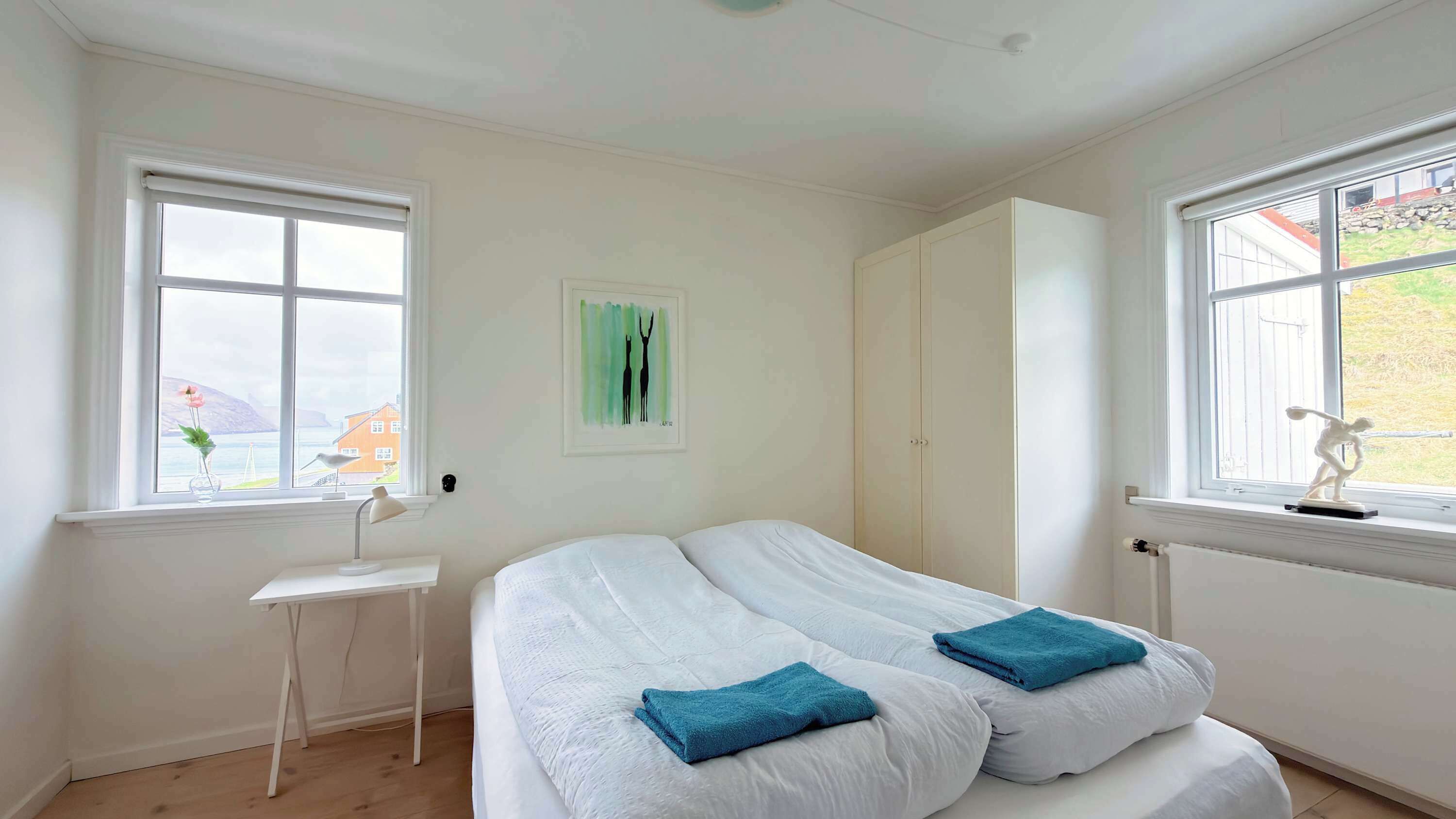 Une chambre avec un lit, un bureau et une fenêtre donnant sur un beau paysage.