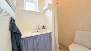 A bathroom with a white sink, a mirror, a towel rack, and a toilet. - Oceanfront Home Near Vagar Airport (Sørvágur)