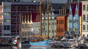 A harbor with colorful buildings and a large blue boat docked.