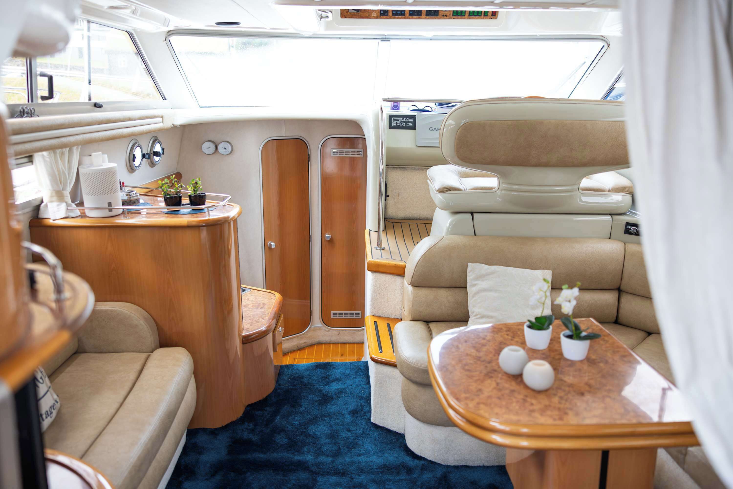 A cozy interior with a wooden table, cushioned seating, and a blue carpet.