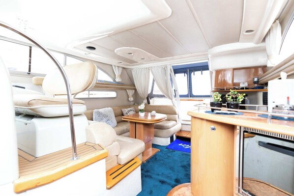 A compact, well-lit interior with a kitchenette, seating area, and a small dining table.