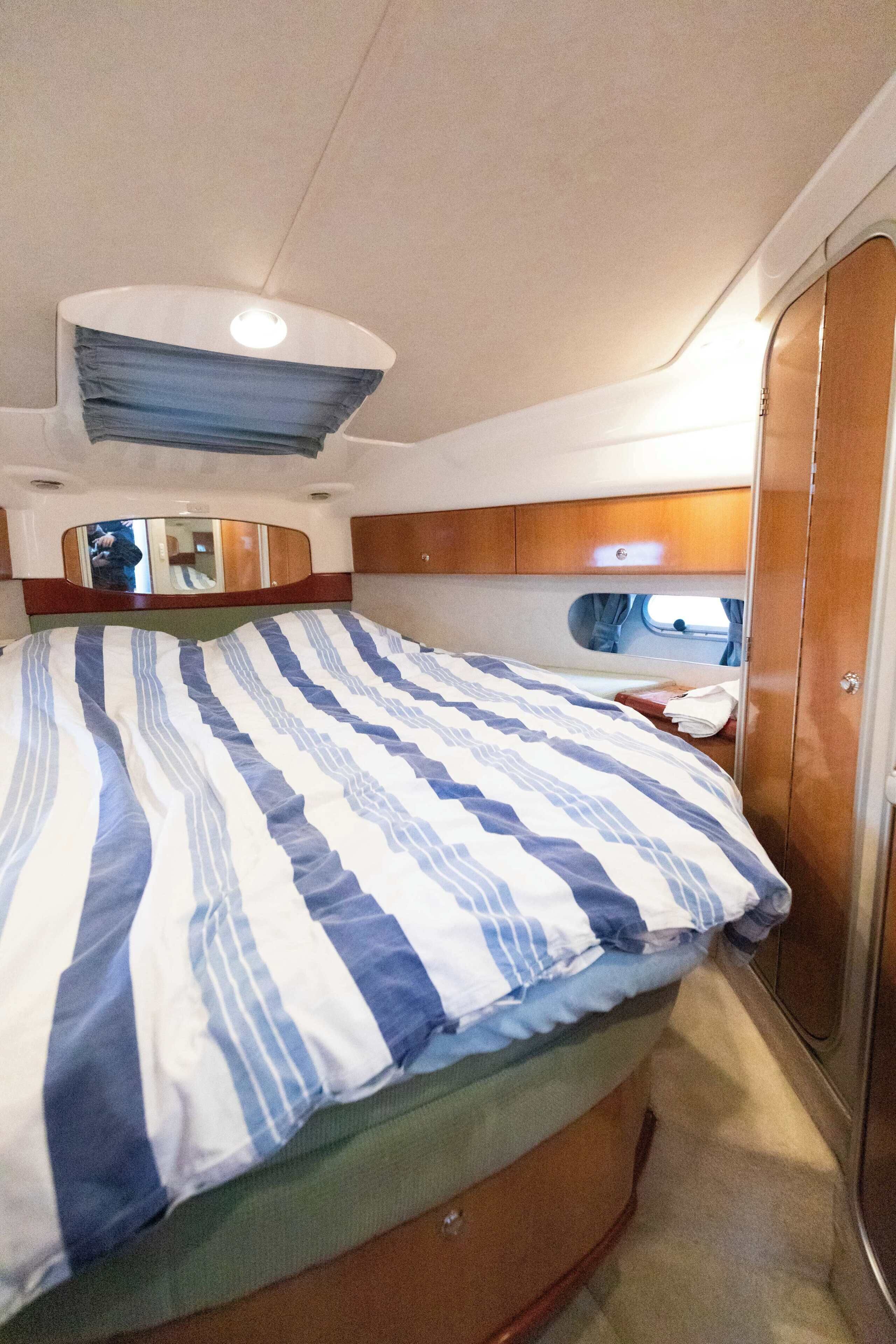 A compact bedroom with a bed, a mirror, and a wardrobe.
