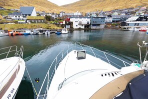 A harbor with boats docked and a town in the background.