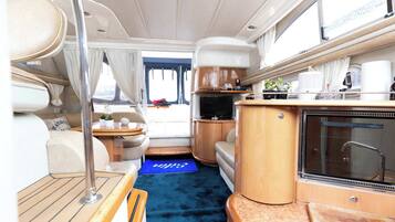 Interior compacto de una caravana con kitchenette, zona de estar y una pequeña mesa.