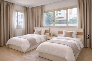 A hotel room with two beds, a nightstand, and a window with curtains. - Twin Room in a Luxury Villa-New Cairo (New Cairo)