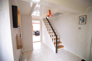 Una escalera de madera con barandillas negras que conduce a un piso superior.