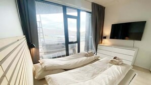 Une chambre d’hôtel avec deux lits, une télévision et une fenêtre donnant sur la ville.