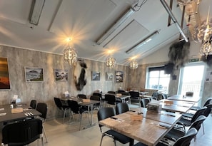 A conference room with tables, chairs, and a chandelier. - Modern 4BR Luxury Home with Ocean View & Jacuzzi (Sandavágur)